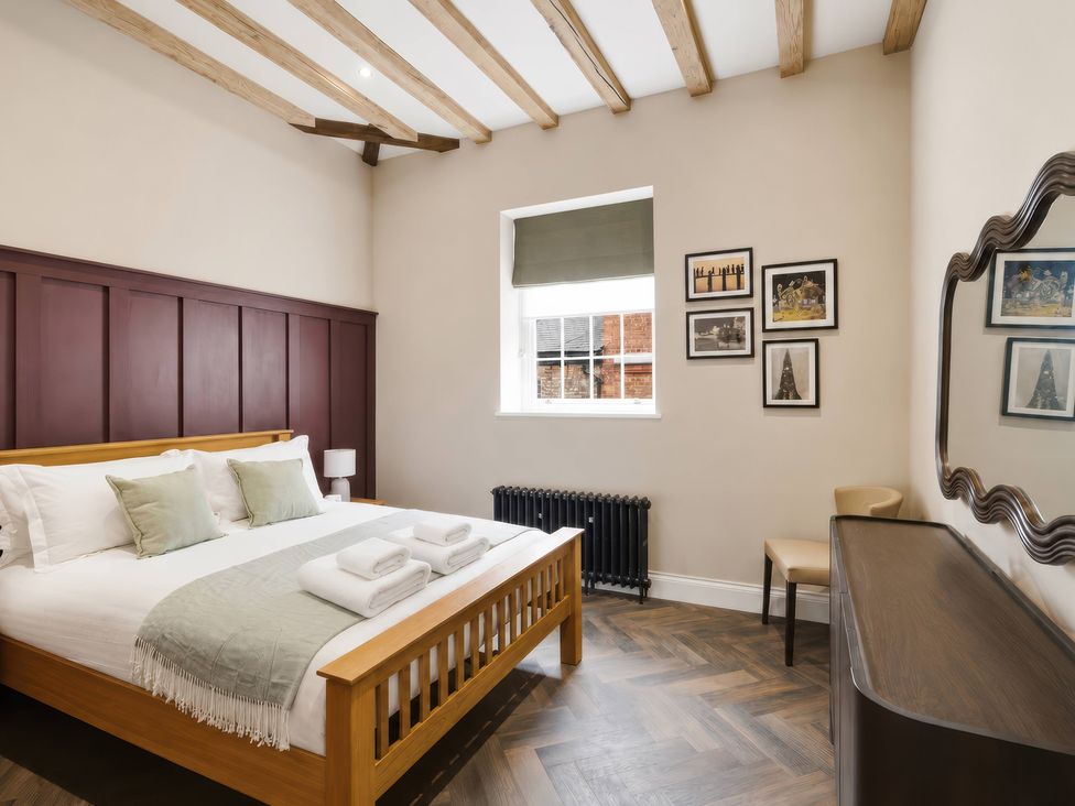 A bedroom with a bed, table, and pictures at Apt. 3 in York