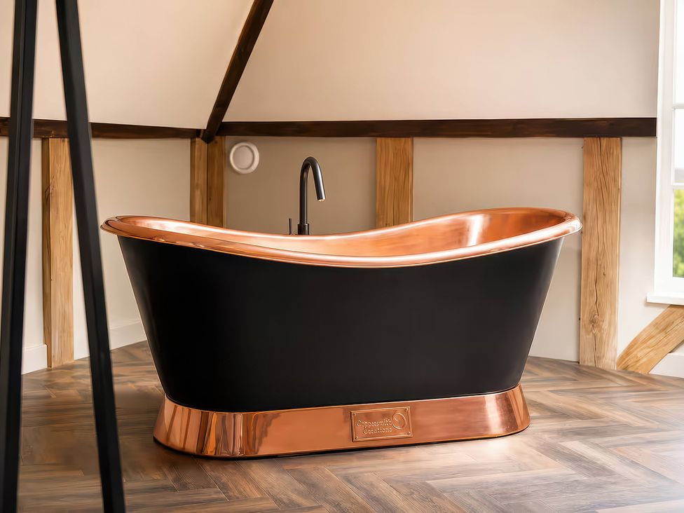 A bathroom with a black and copper bathtub at Apt. 3 in York