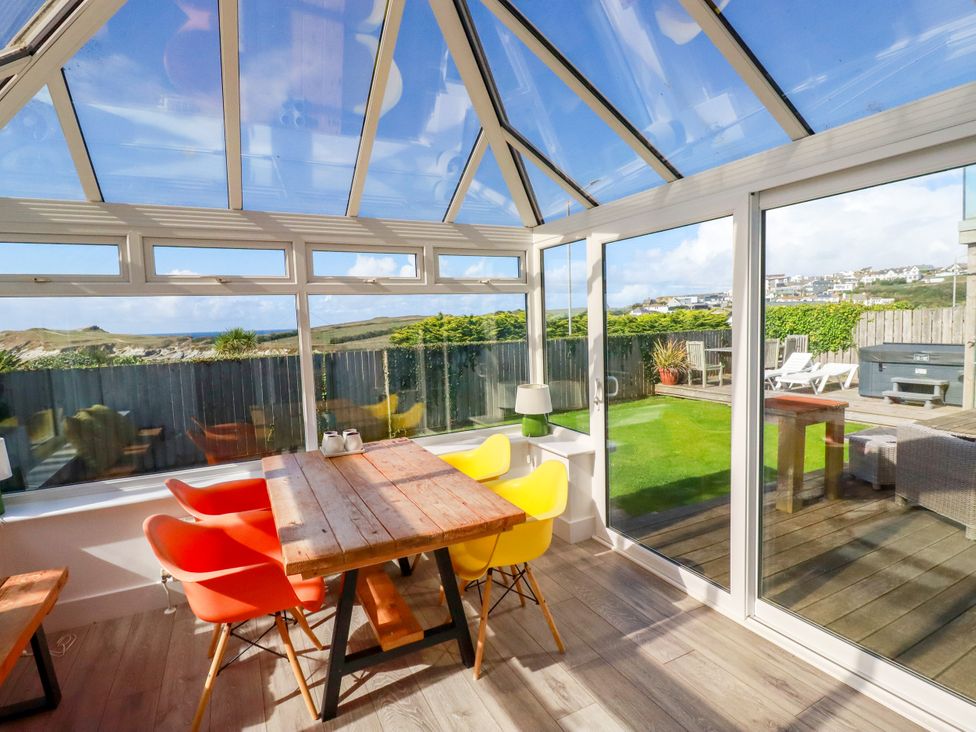 A conservatory with a table and chairs at Mermaid Gaze in Newquay