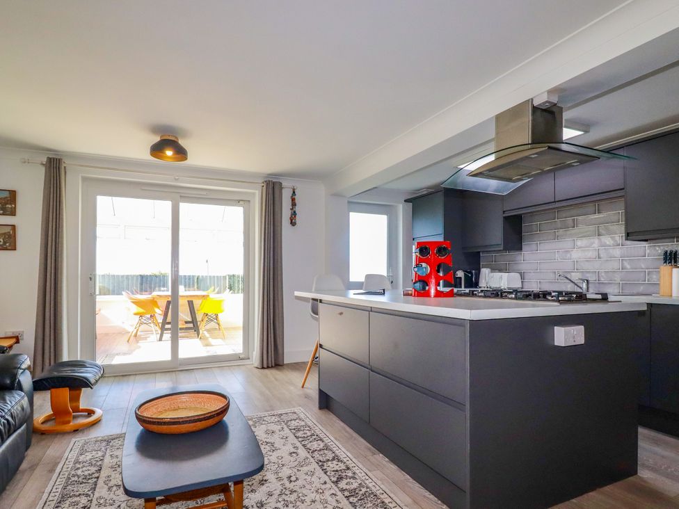 A kitchen with a stove and kitchen island at Mermaid Gaze in Newquay