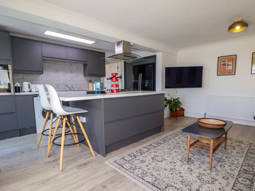 A kitchen with a kitchen island and stools at Mermaid Gaze in Newquay