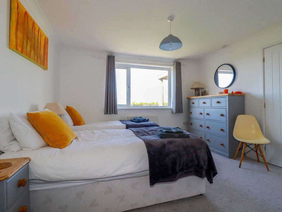 A bedroom with two beds and a dresser at Mermaid Gaze in Newquay