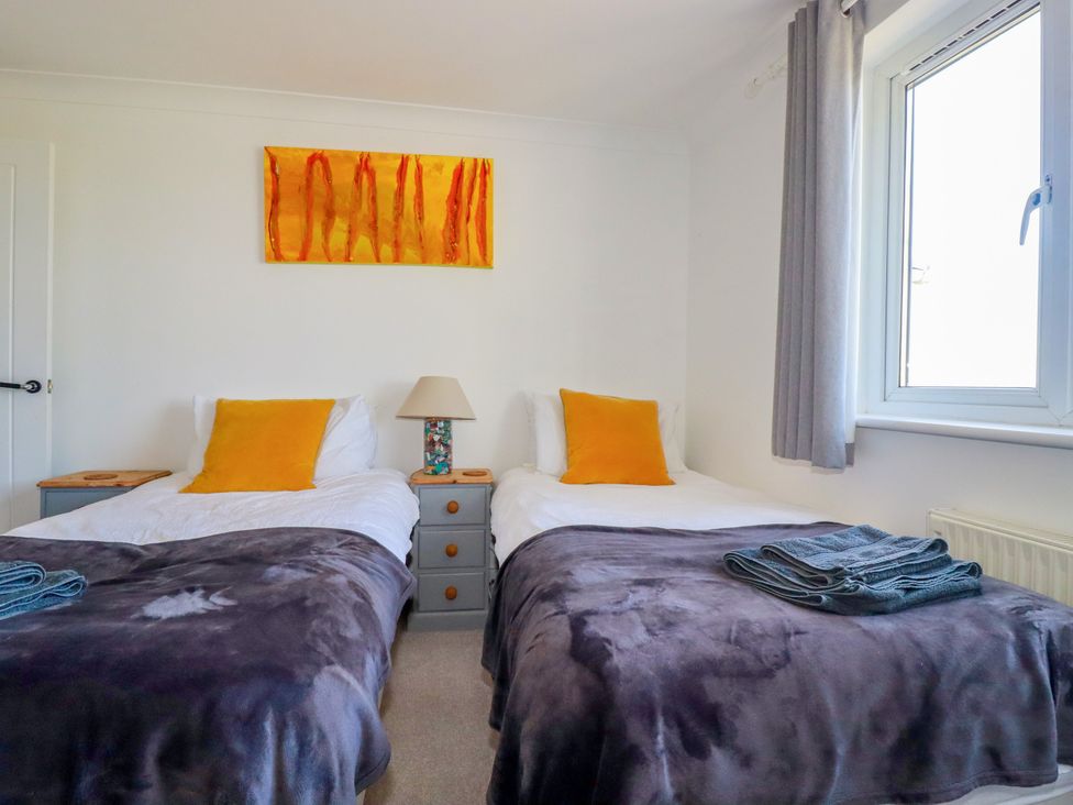 A bedroom with two beds and a lamp at Mermaid Gaze in Newquay