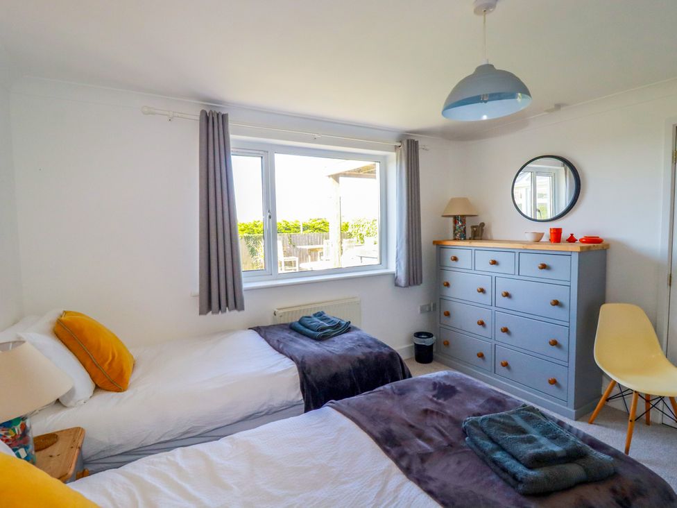 A bedroom with two beds and a dresser at Mermaid Gaze in Newquay