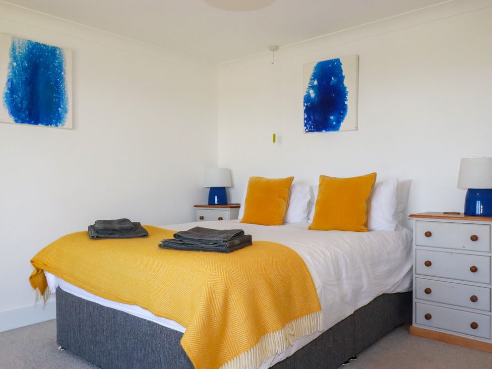 A bedroom with a bed and bedside tables at Mermaid Gaze in Newquay