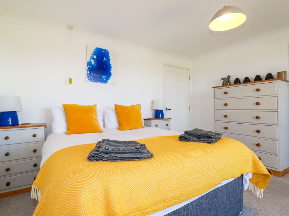 A bedroom with a bed and bedside tables at Mermaid Gaze in Newquay