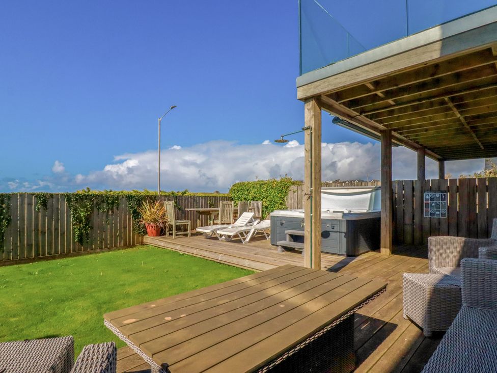 A garden with a hot tub and outdoor seating at Mermaid Gaze in Newquay