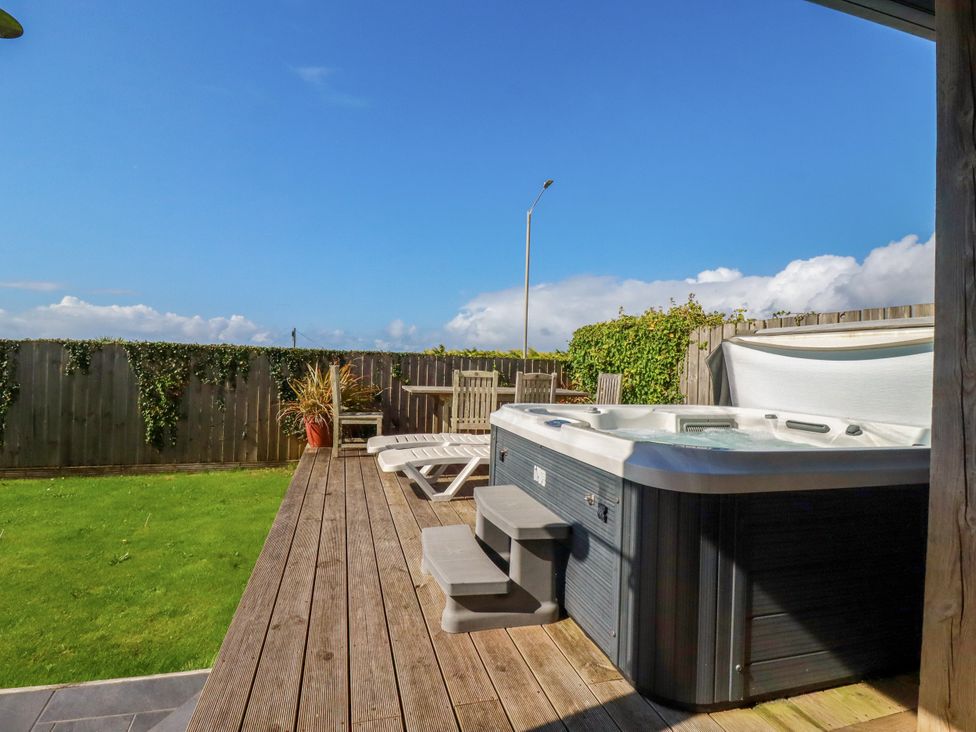 A garden with a hot tub and outdoor furniture at Mermaid Gaze in Newquay