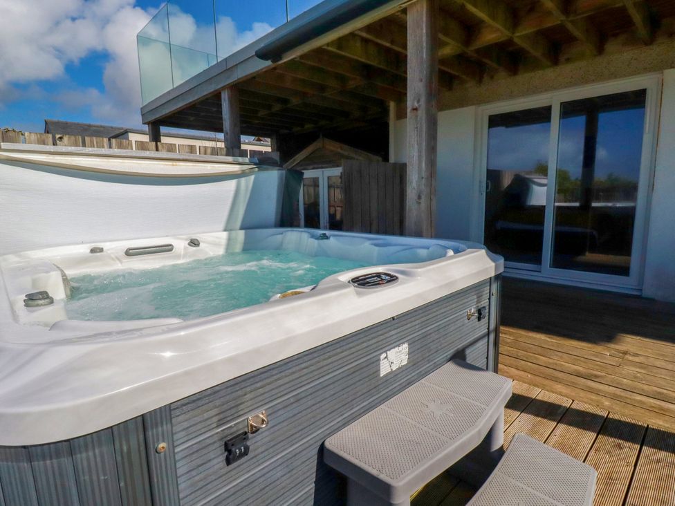 A hot tub with steps and sliding doors at Mermaid Gaze in Newquay