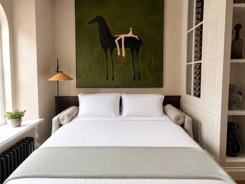 A bedroom with a bed and an artwork featuring a horse at Apt.4 York