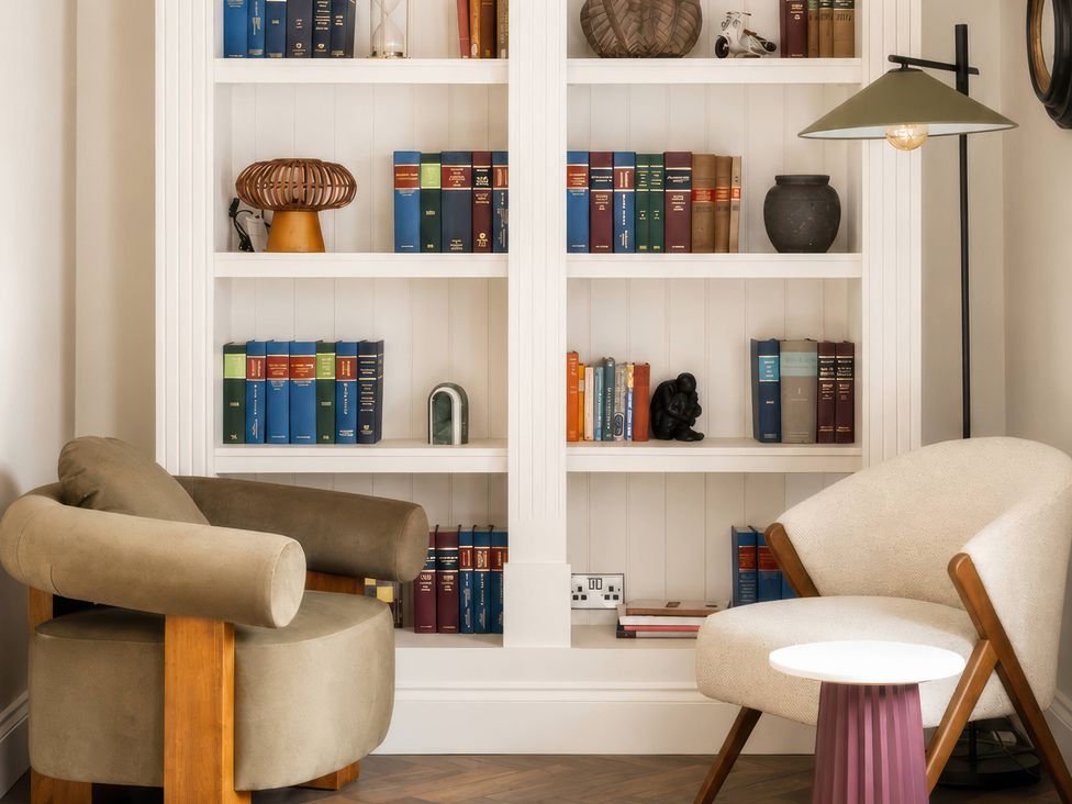 A reading nook with a bookshelf and two chairs at Apt.4 in York