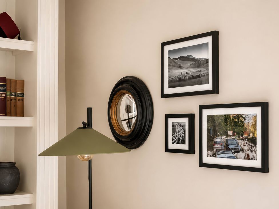 A living room with books on a shelf and framed pictures on the wall at Apt.4 in York