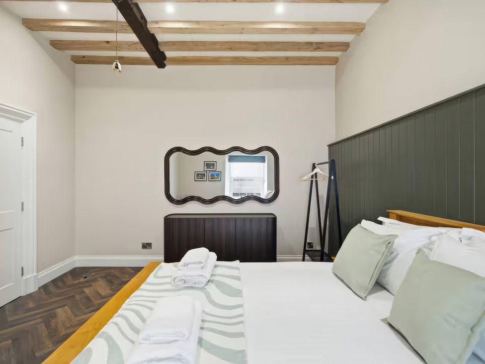 A bedroom with a bed and a mirror at Apt.4 in York