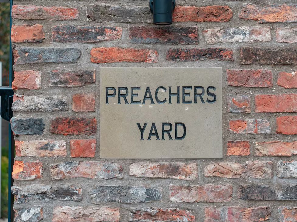 A sign labeled PREACHERS YARD on a brick wall at Apt.4 in York