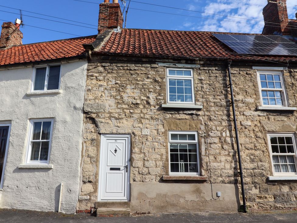 A brick house with windows and door at Blue Cottage in Malton