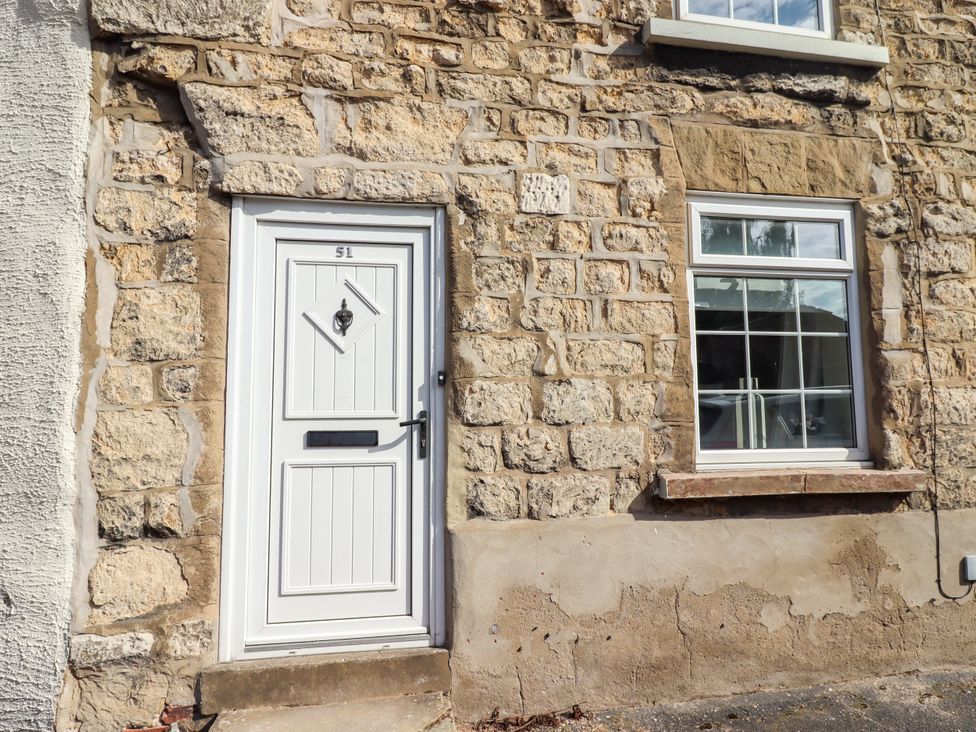 A door and window on a stone wall at Blue Cottage in Malton