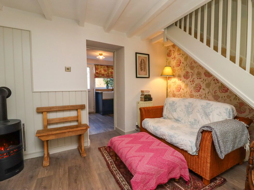 A living room with a sofa and stove at Blue Cottage in Malton