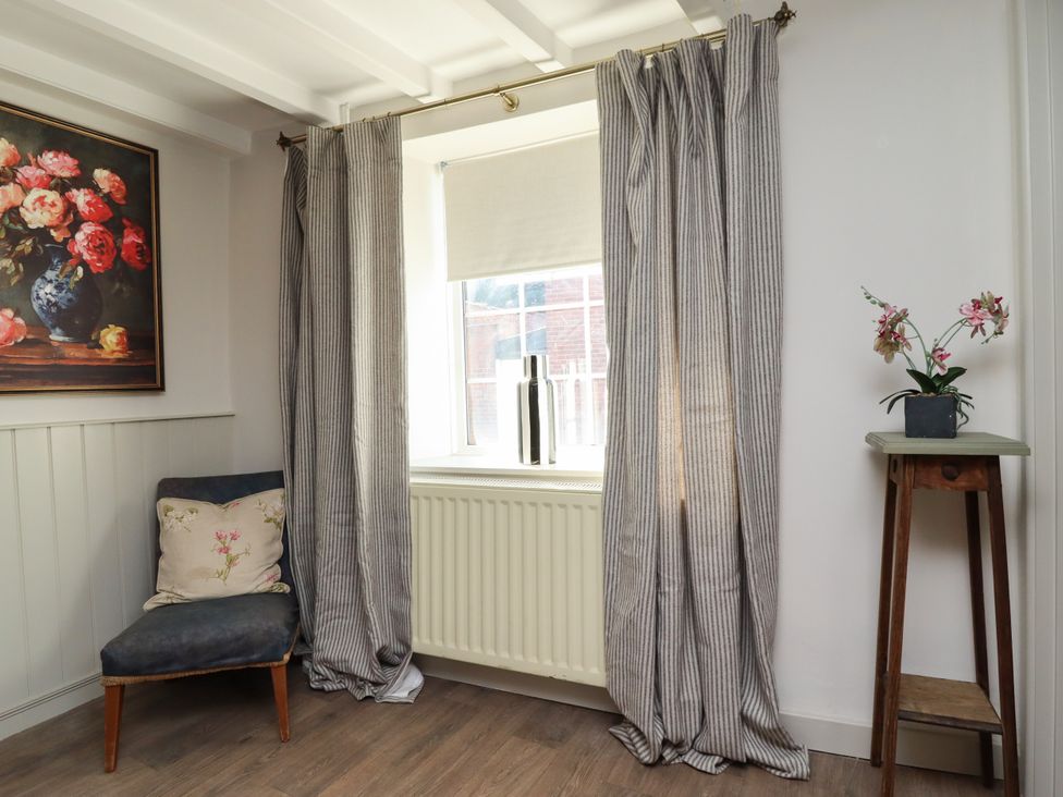 A living room with a chair and a window at Blue Cottage in Malton
