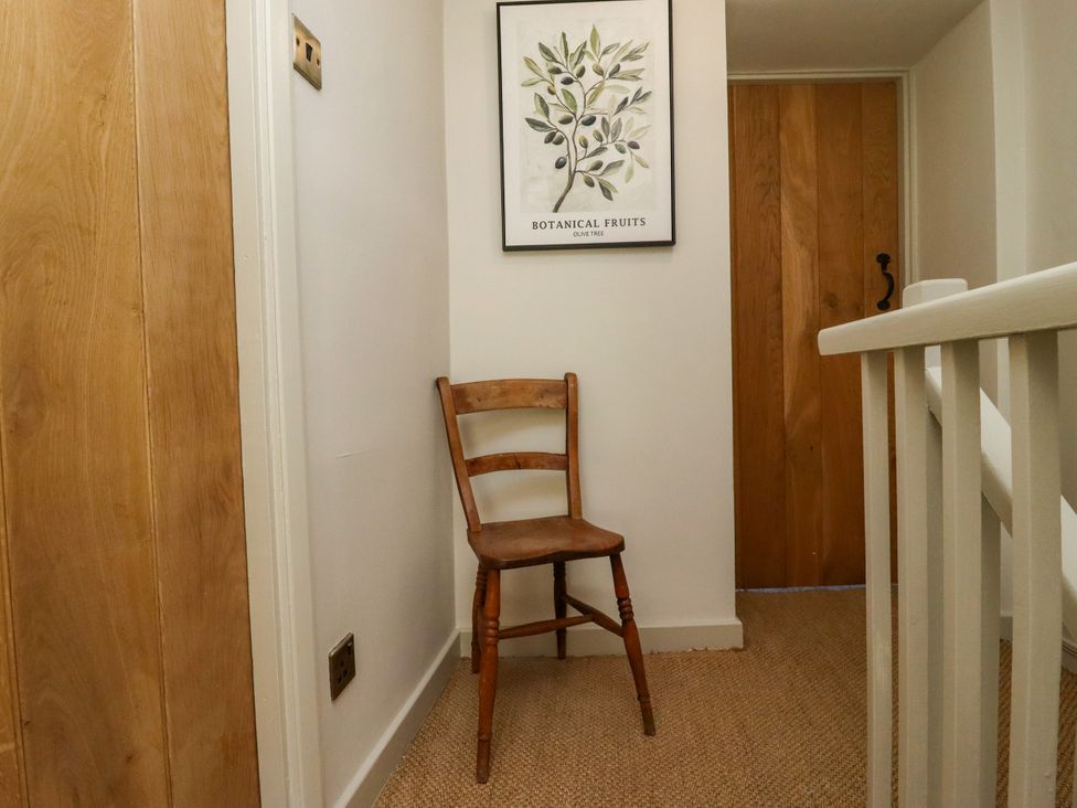 A hallway with a chair and an artwork at Blue Cottage in Malton