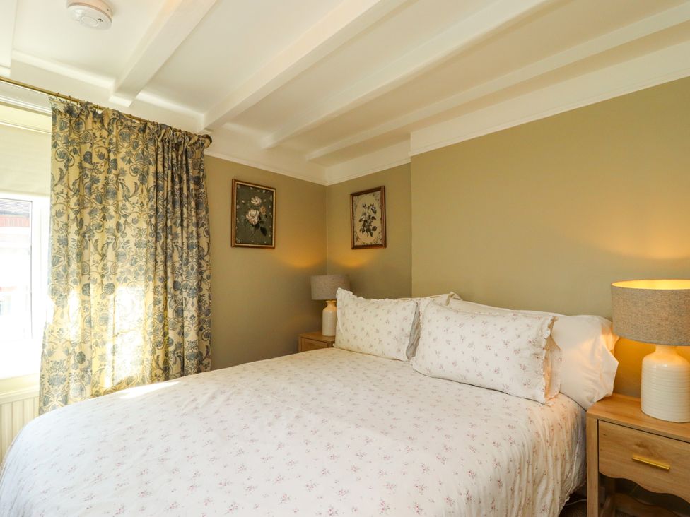 A bedroom with a bed and curtains at Blue Cottage in Malton