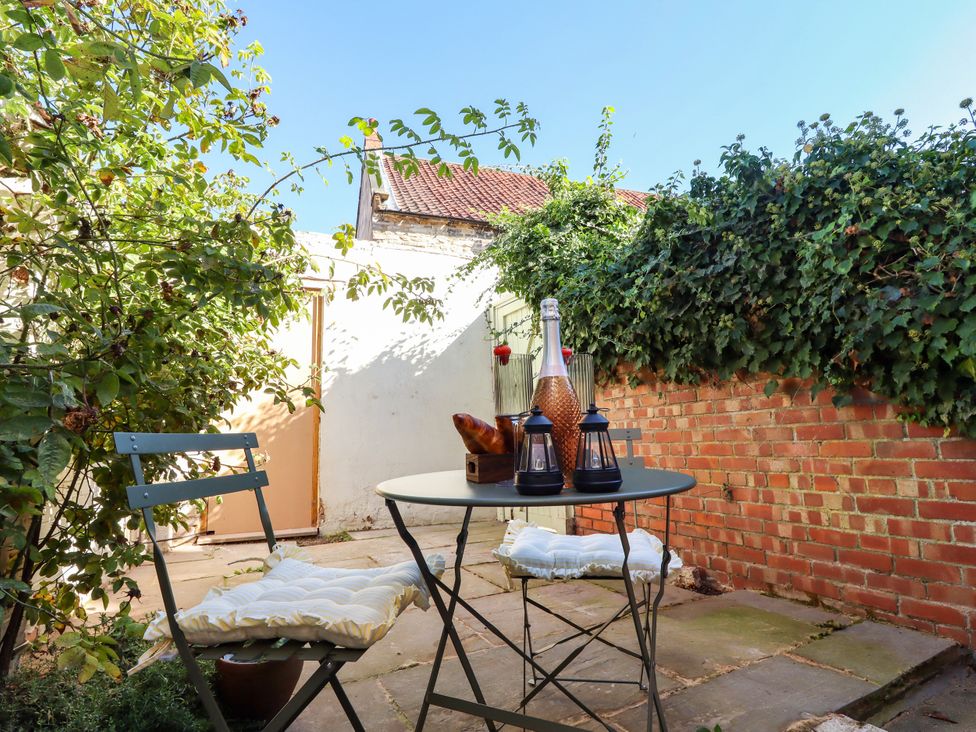 A garden with a table and chairs at Blue Cottage in Malton