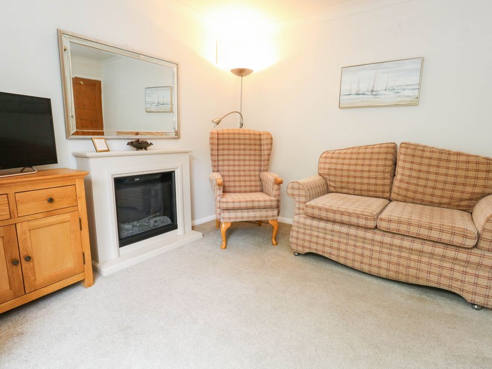 A living room with a sofa and armchair at Sunnydale near Corfe Mullen