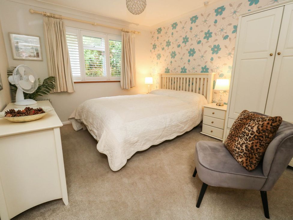 A bedroom with a bed and bedside table at Sunnydale near Corfe Mullen