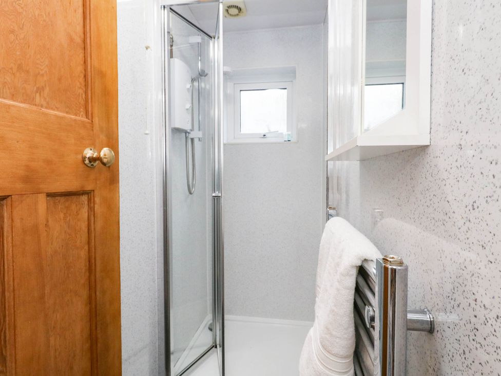 A bathroom with a shower and towel at Sunnydale near Corfe Mullen