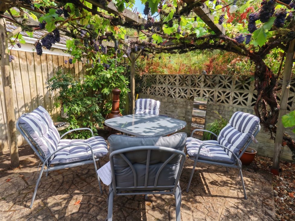 A garden seating area with a table and chairs at Sunnydale near Corfe Mullen