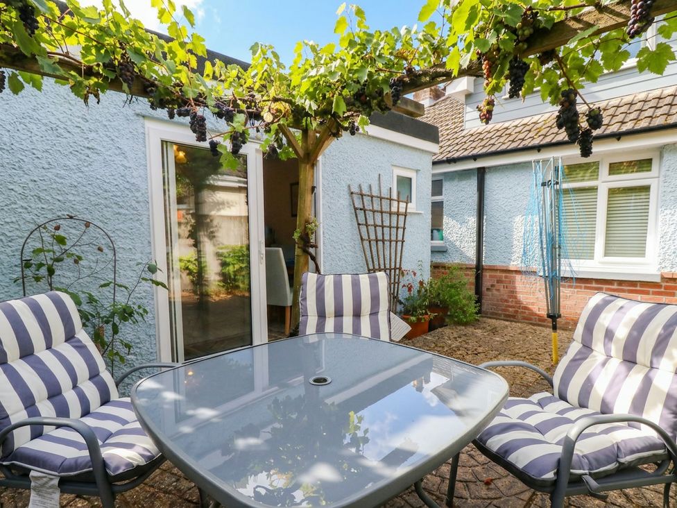 A garden with a table and chairs under a grapevine at Sunnydale near Corfe Mullen