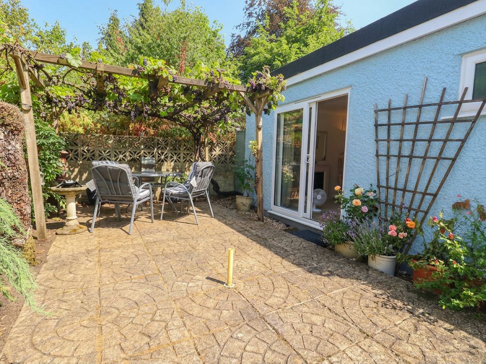 A garden with an outdoor patio and seating area at Sunnydale near Corfe Mullen