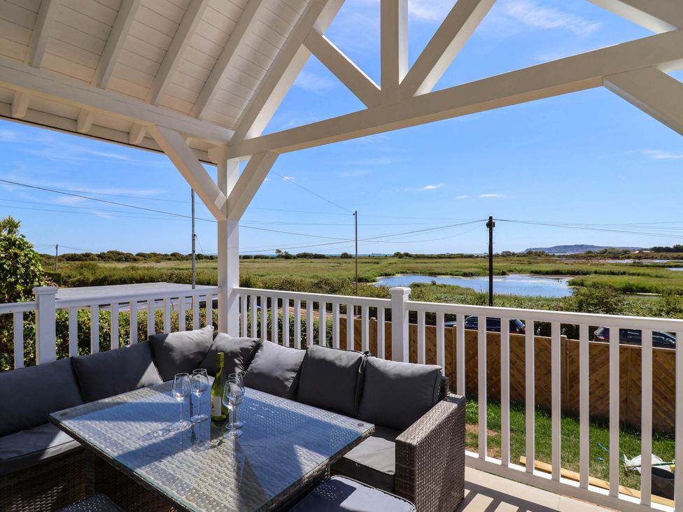 An outdoor seating area with a table and couch at 30 Southdown Avenue Weymouth