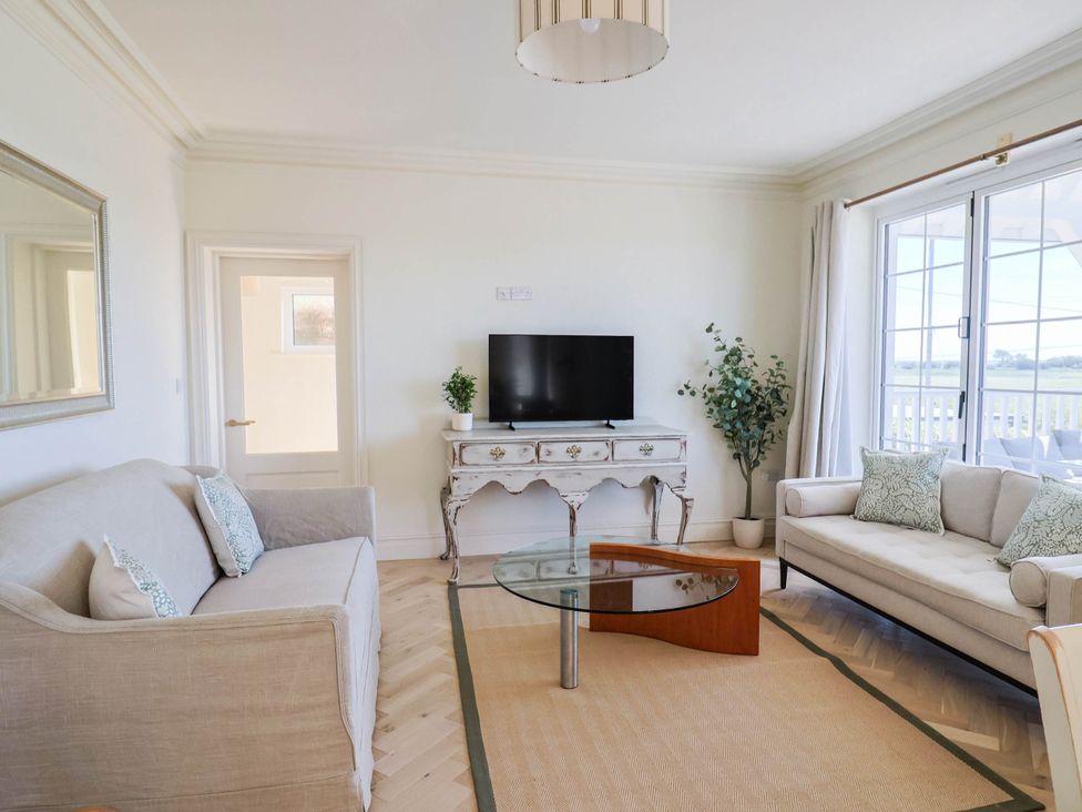 A living room with a television and two sofas at 30 Southdown Avenue Weymouth