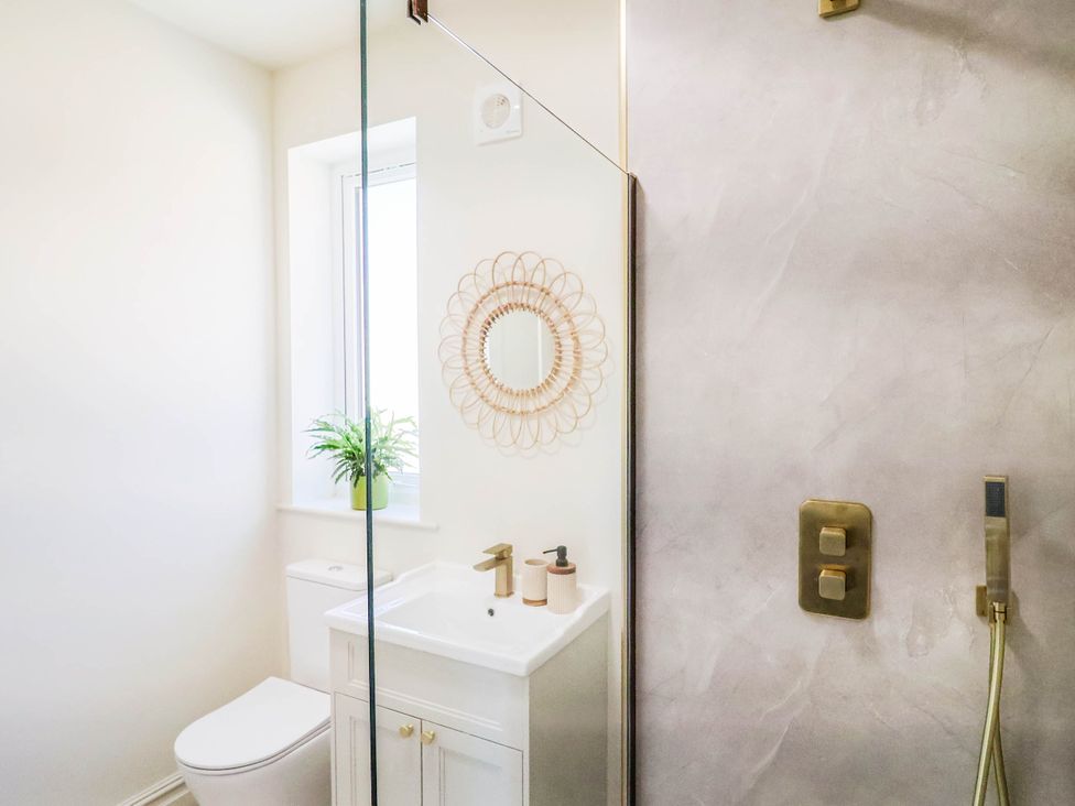 A bathroom with a toilet, sink, and shower at 30 Southdown Avenue, Weymouth
