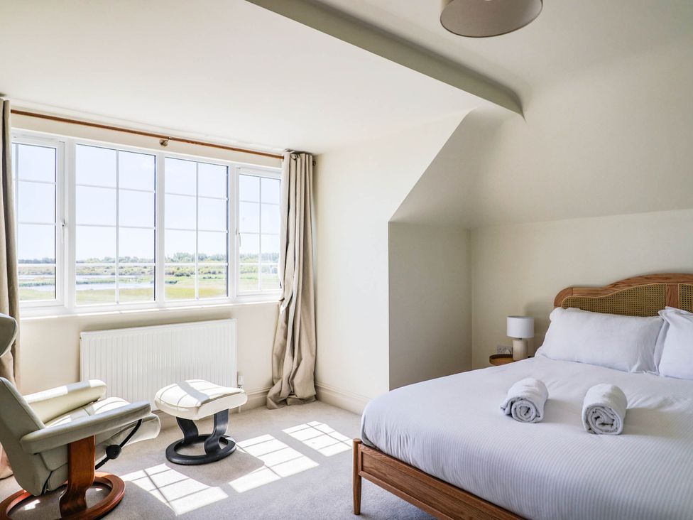 A bedroom with a bed and armchair at 30 Southdown Avenue, Weymouth