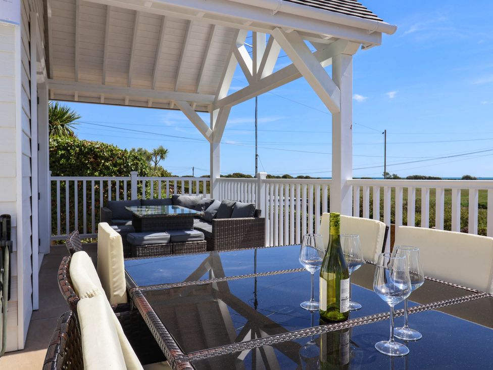 An outdoor patio with a table and sofa at 30 Southdown Avenue Weymouth