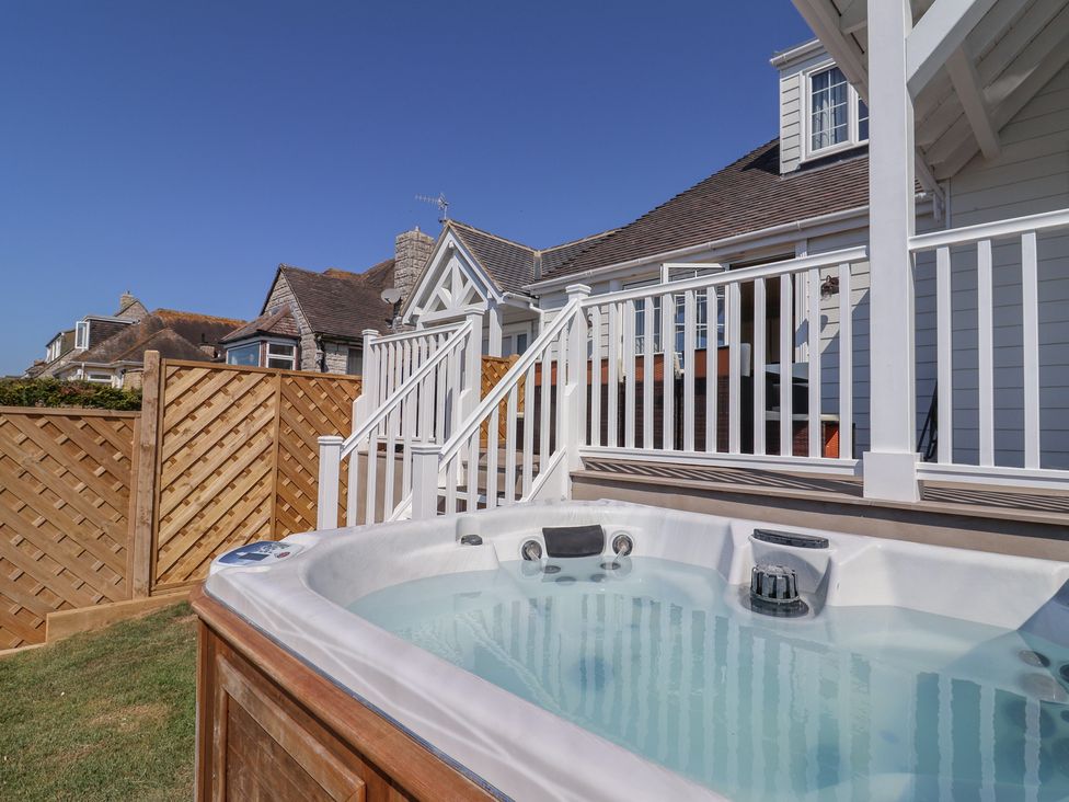 A hot tub on a deck with a view of a house at 30 Southdown Avenue Weymouth
