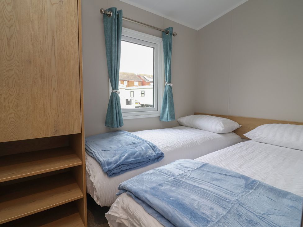A bedroom with two beds and a window at S7 Abergele