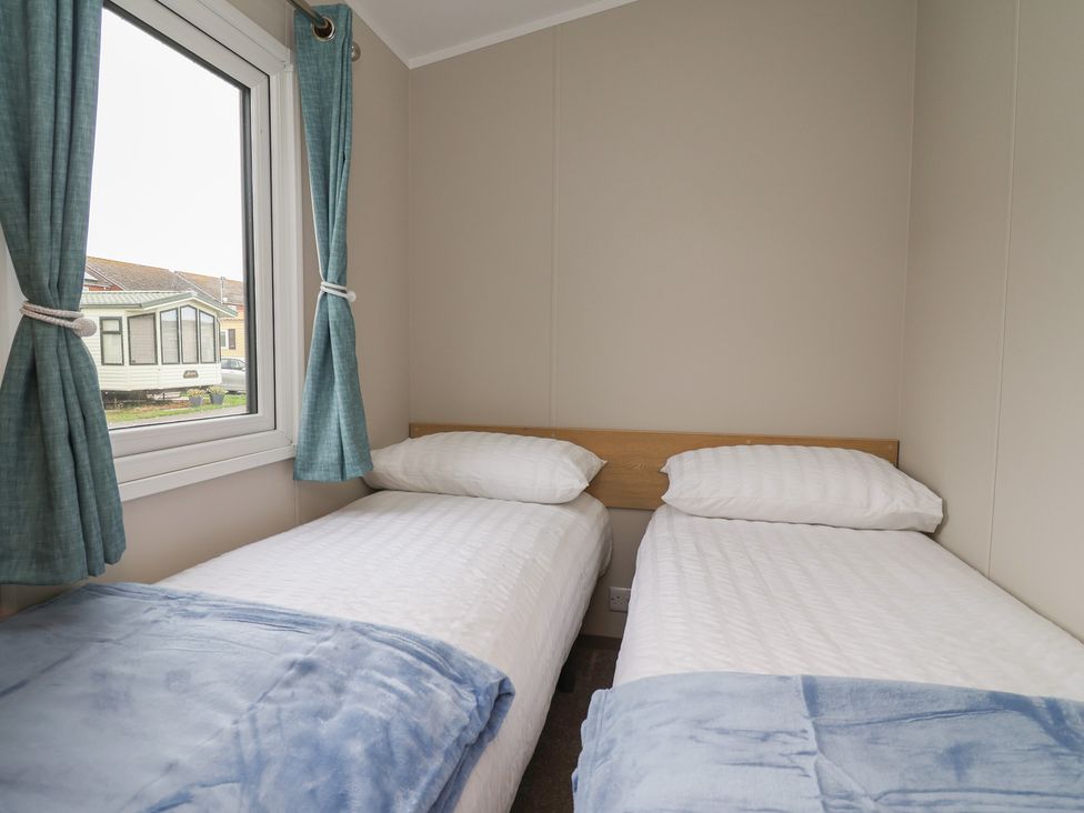 A bedroom with two single beds and a window at S7 Abergele