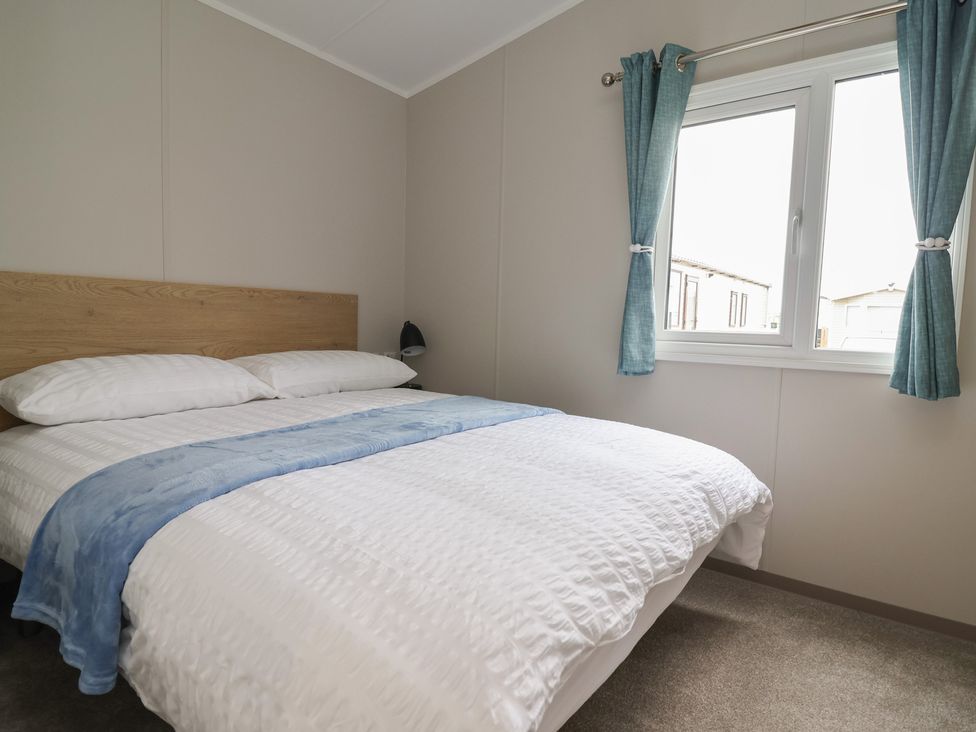 A bedroom with a bed and a window at S7 in Abergele