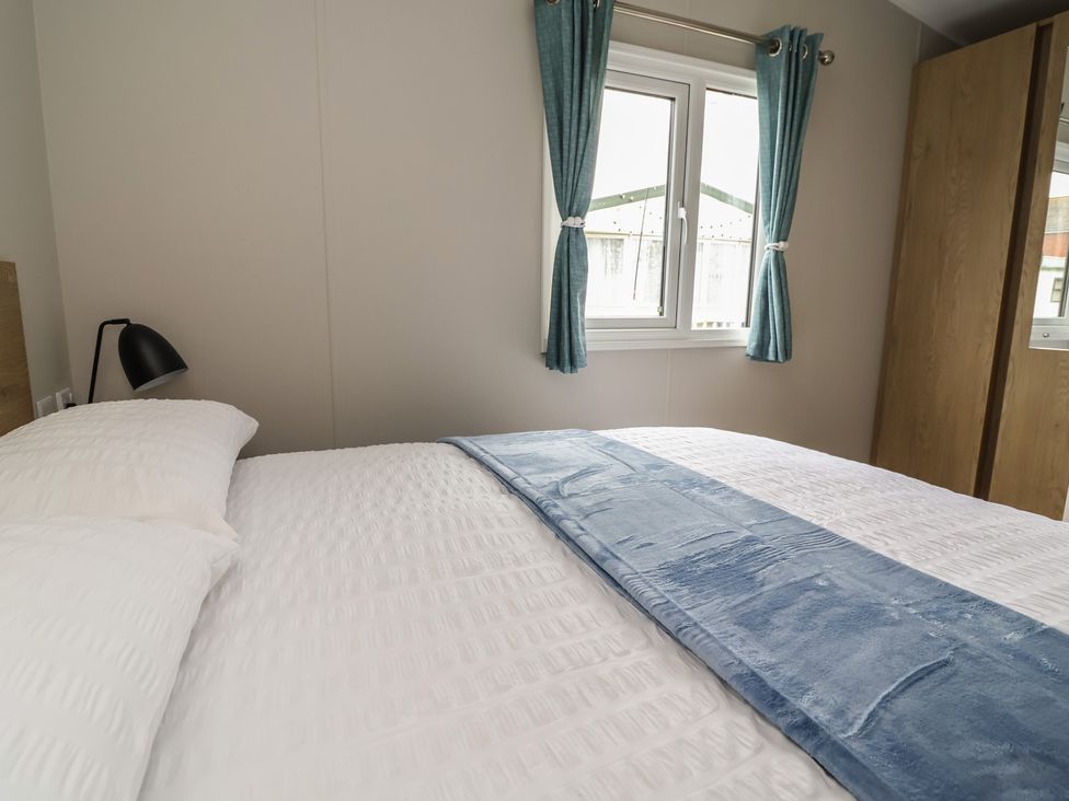 A bedroom with a bed and curtains at S7 in Abergele