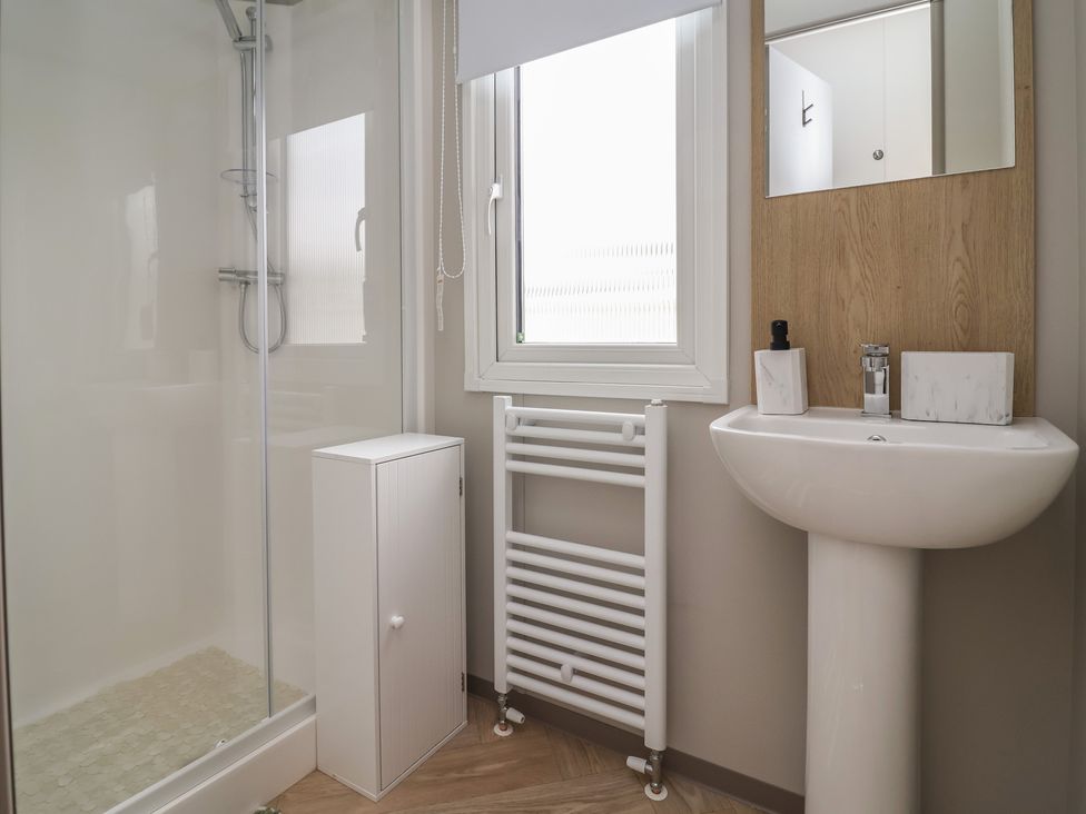 A bathroom with shower, sink and mirror at S7 in Abergele
