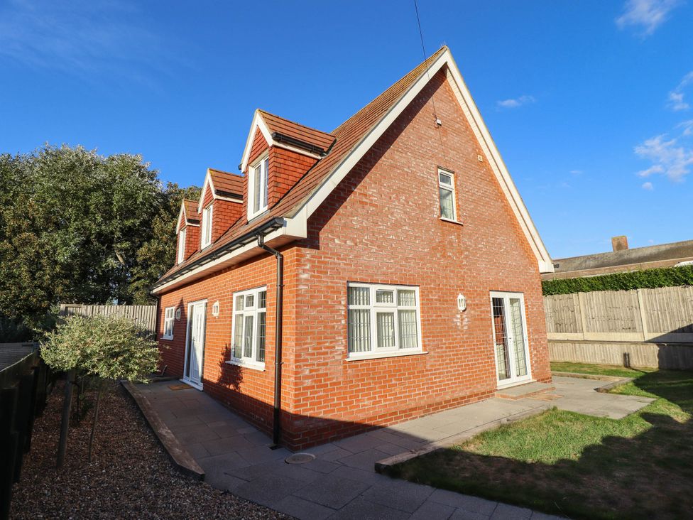 A house with a brick exterior and patio at Beach Lodge