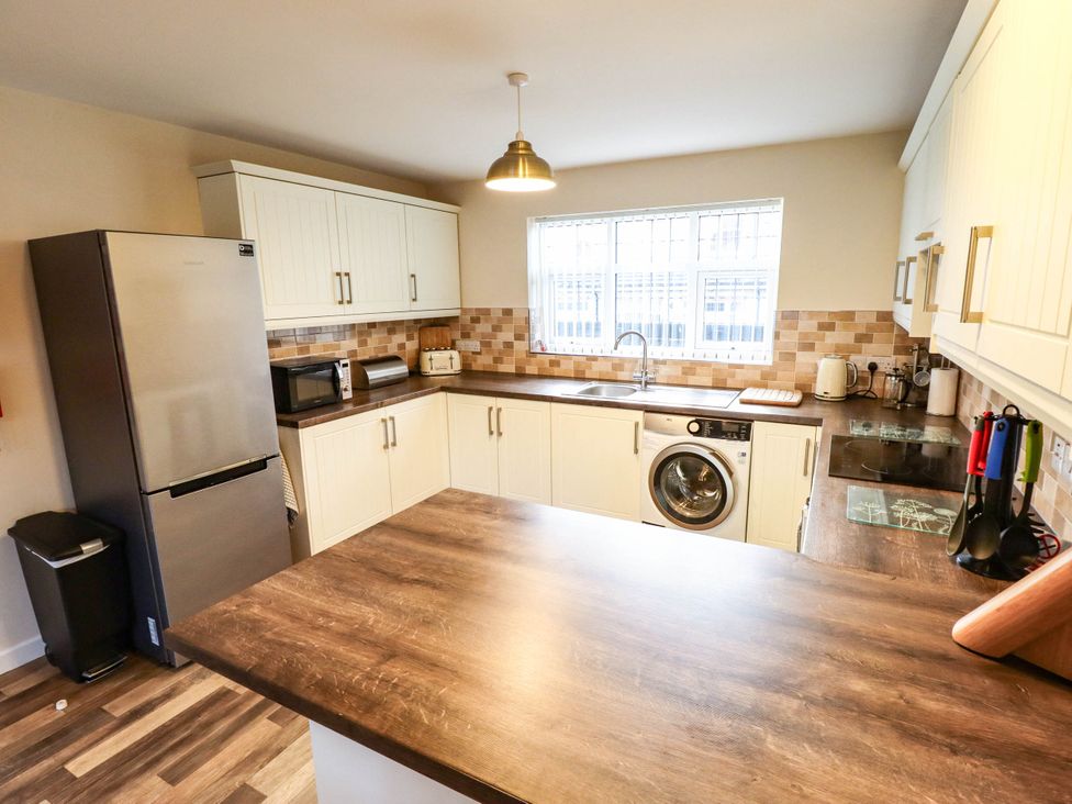 A kitchen with appliances and a window at Beach Lodge