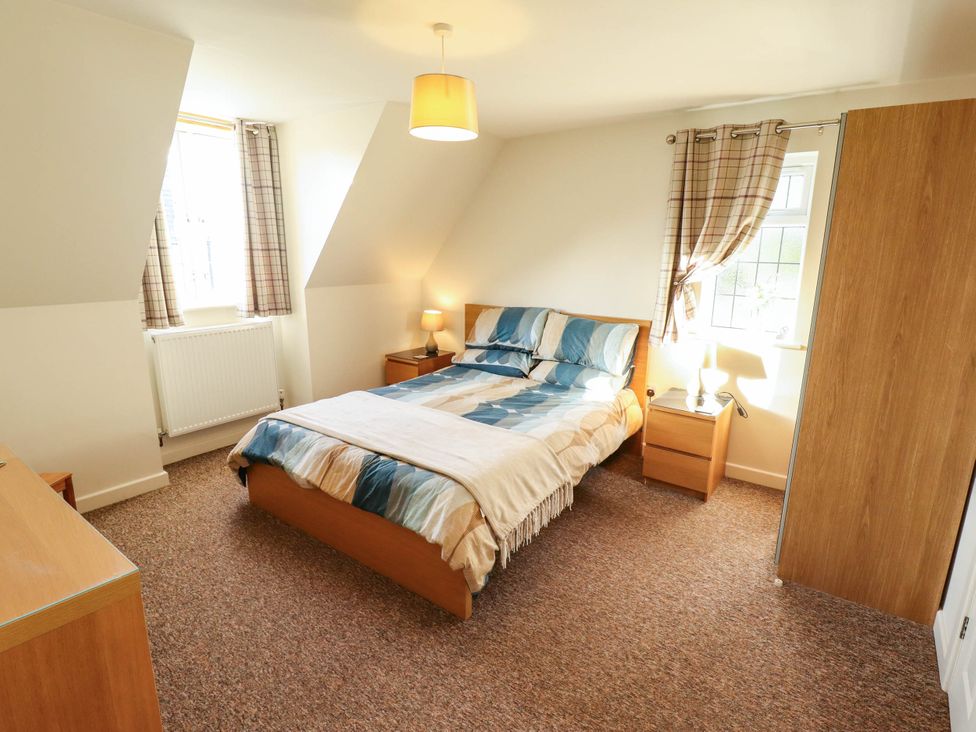 A bedroom with a bed and bedside table at Beach Lodge