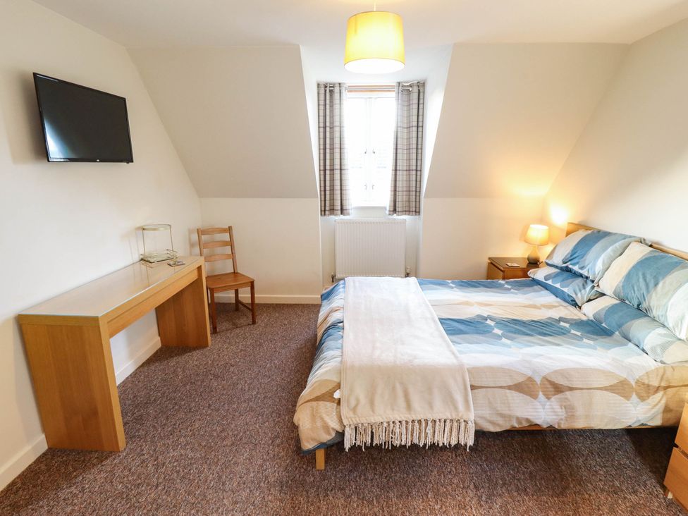 A bedroom with a bed and desk at Beach Lodge