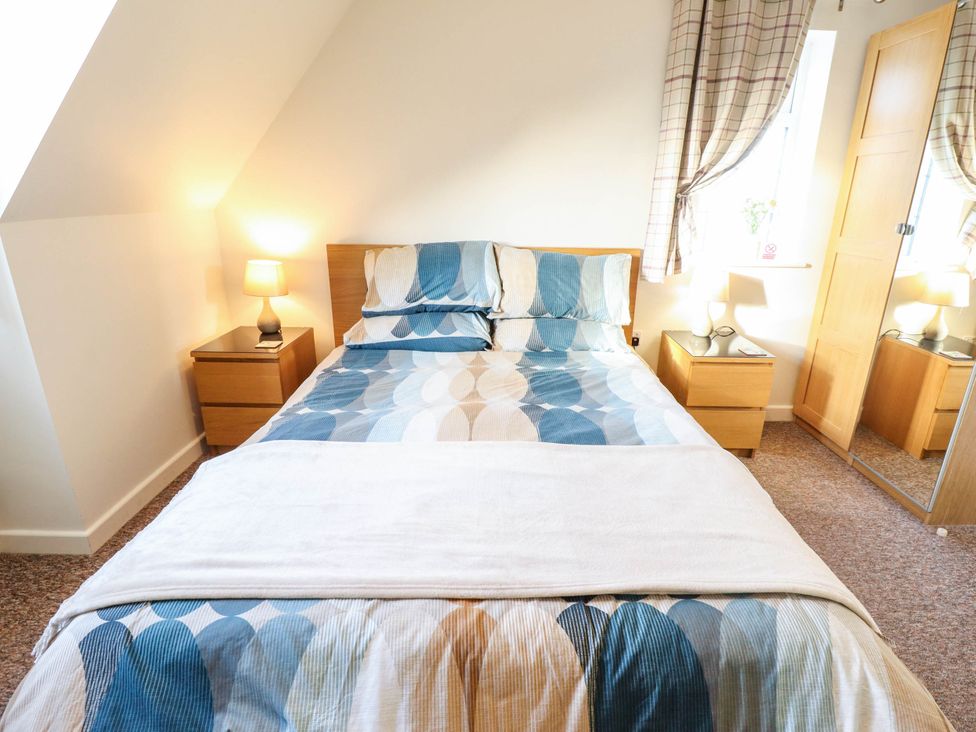 A bedroom with a bed and two bedside tables at Beach Lodge