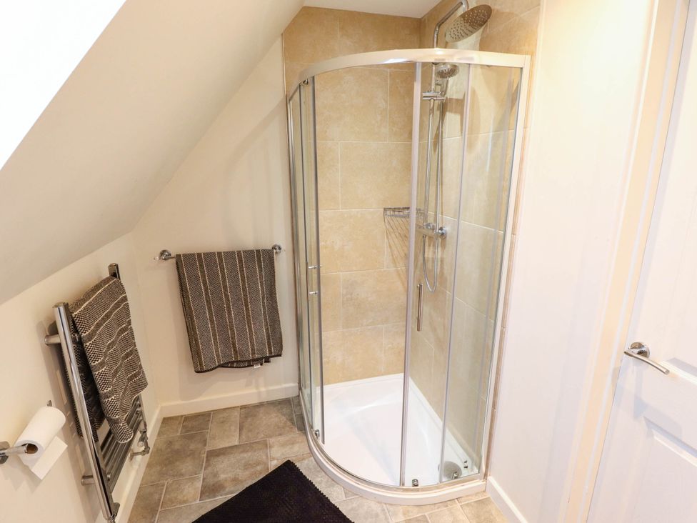 A bathroom with a shower and towel rack at Beach Lodge