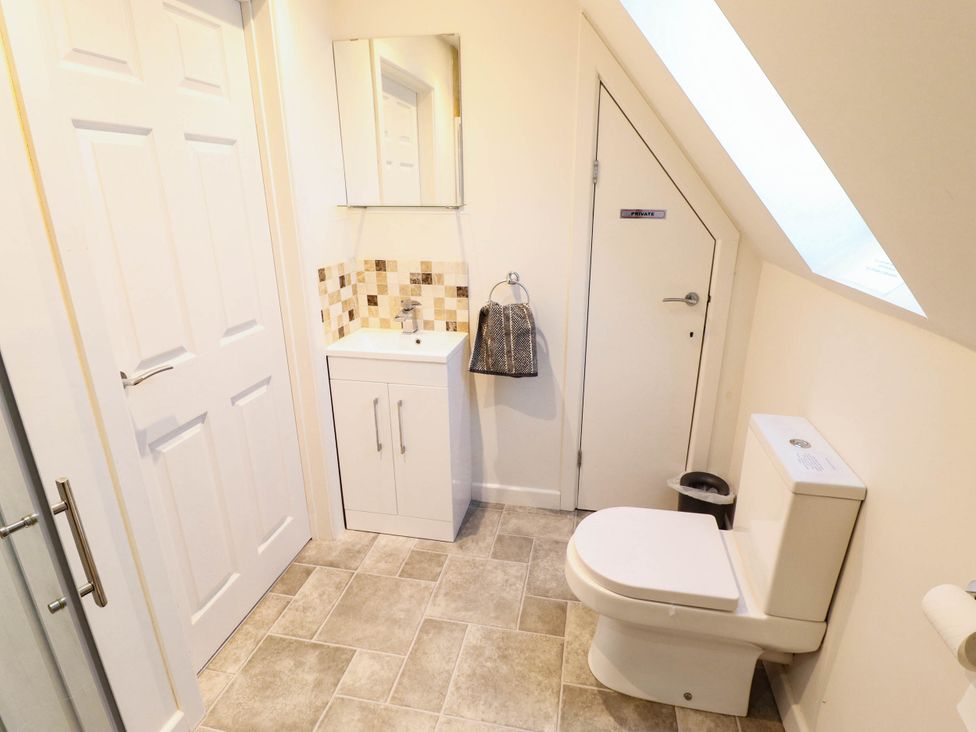 A bathroom with a sink, toilet, and mirror at Beach Lodge