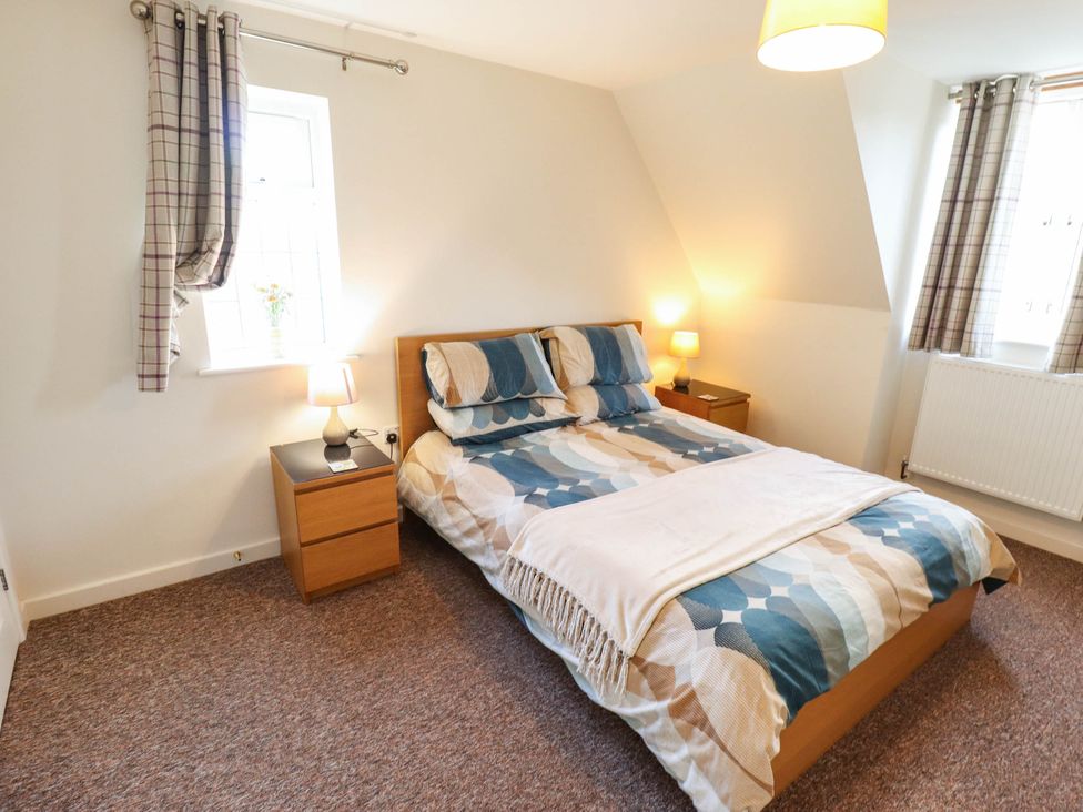 A bedroom with a bed and bedside table at Beach Lodge